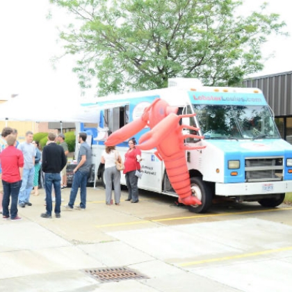 People gathered around a food truck with a large inflatable figure