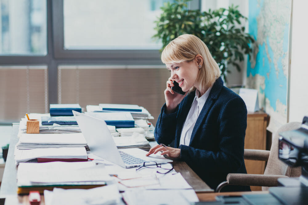 Young woman at the office talking on a cellphone.