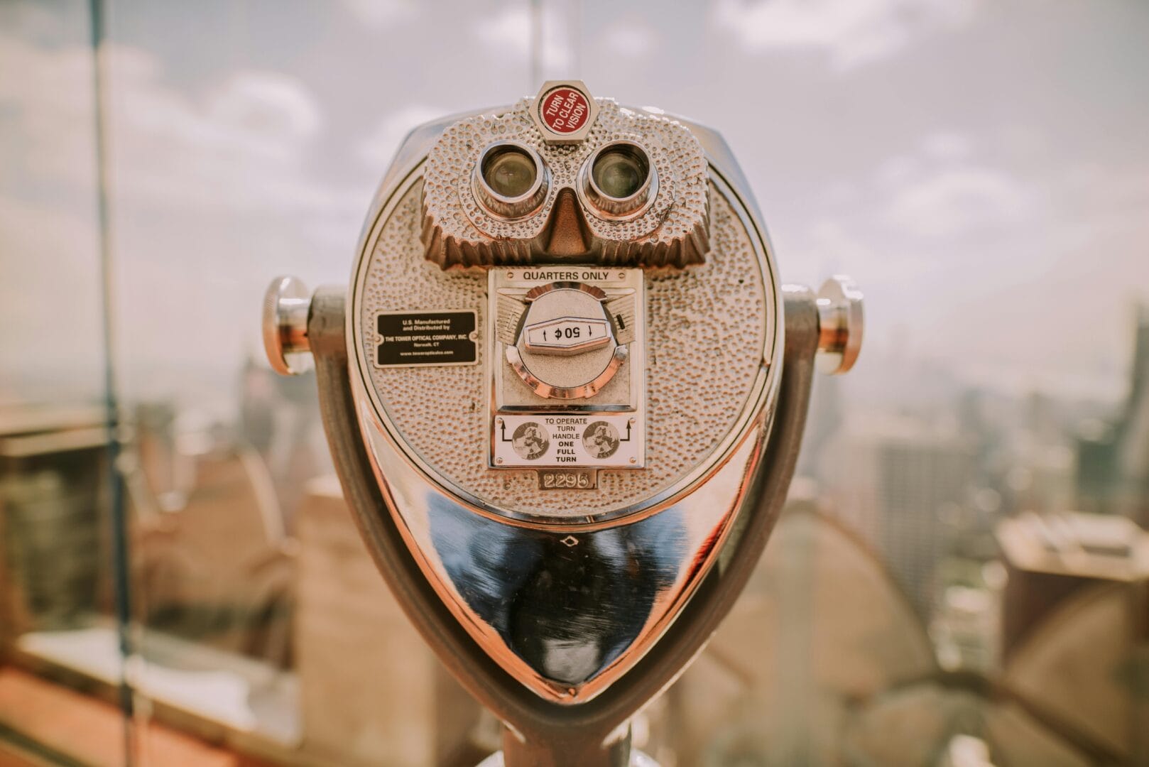 Coin-operated binocular viewer with a cityscape in the background.