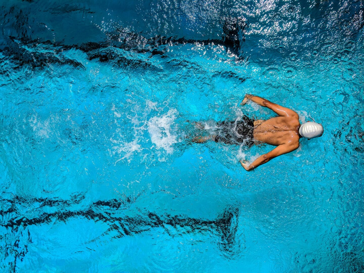 Person swimming in a pool, captured from above.