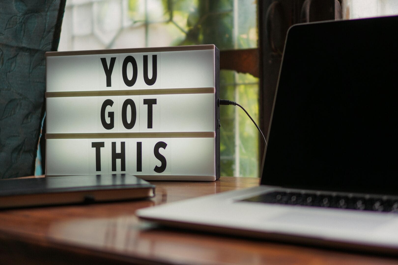 Lightbox with the text 'YOU GOT THIS' on a desk next to a laptop.