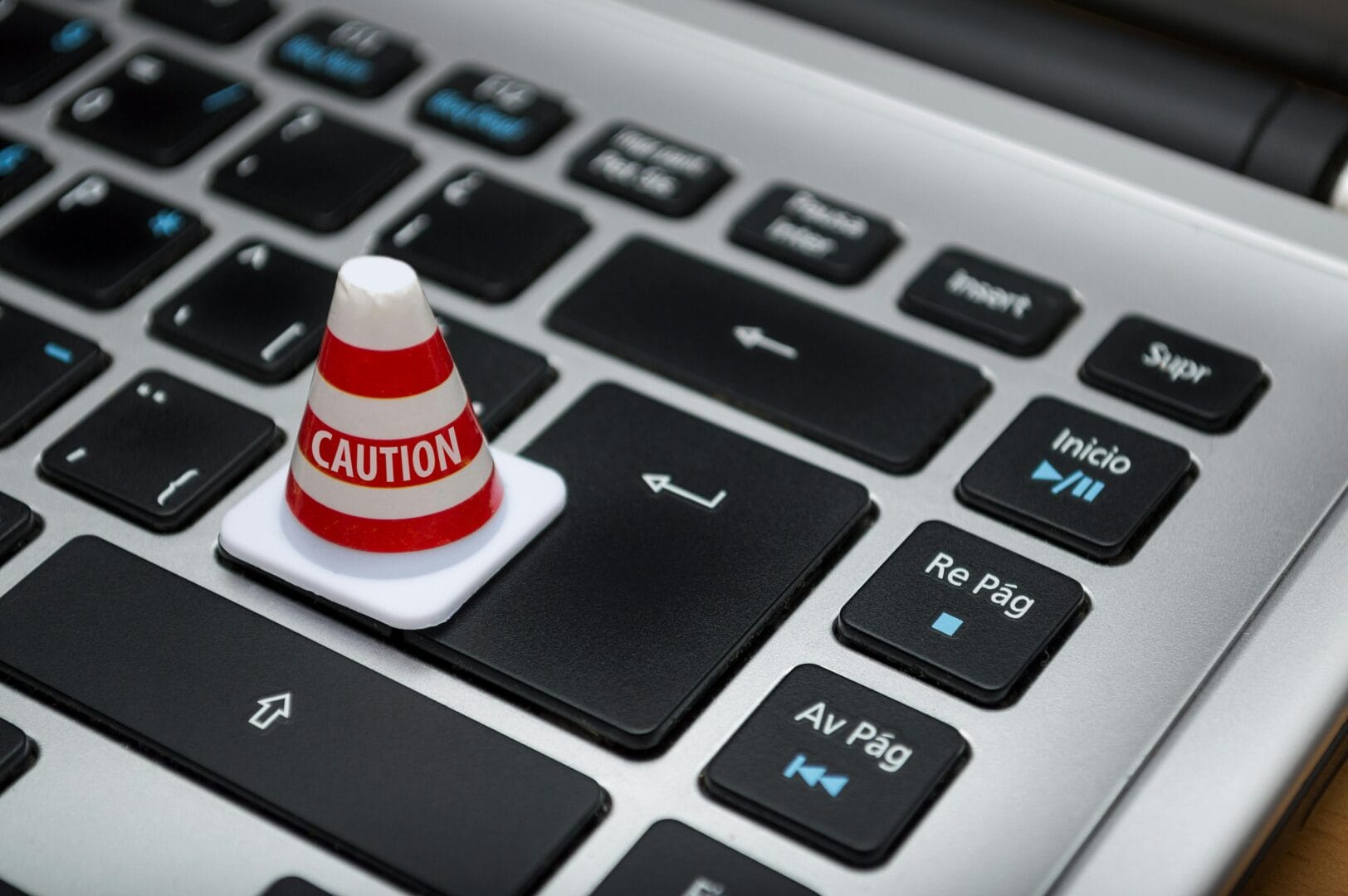 Small caution cone placed on a laptop keyboard.