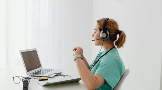 Person wearing a headset, working on a laptop.